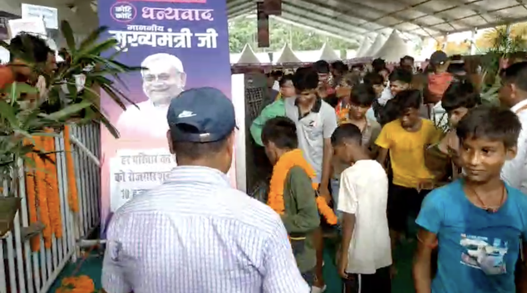 वैशाली में सीएम के कार्यक्रम के दौरान गमला उठाकर ले जाते युवा।