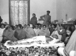 गांधी जी के पार्थिव शरीर के पास शोक में बैठे लोग। (तस्वीर wikimedia.org)