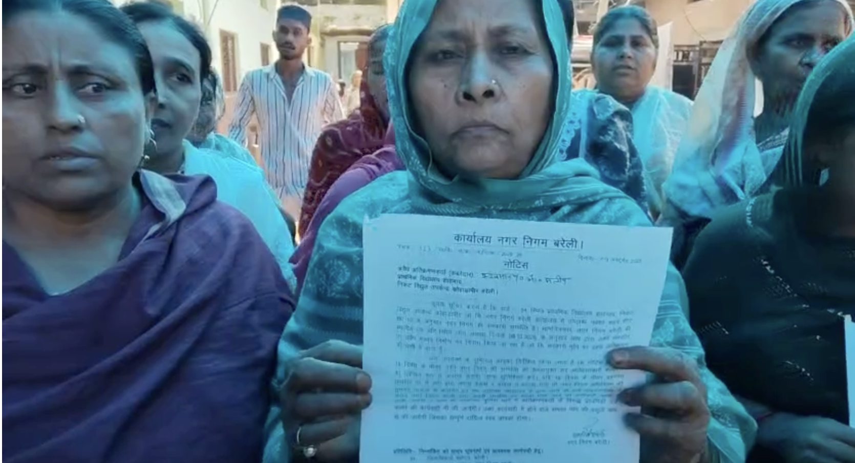 घर खाली करने से जुड़ा नोटिस दिखाती एक महिला।
