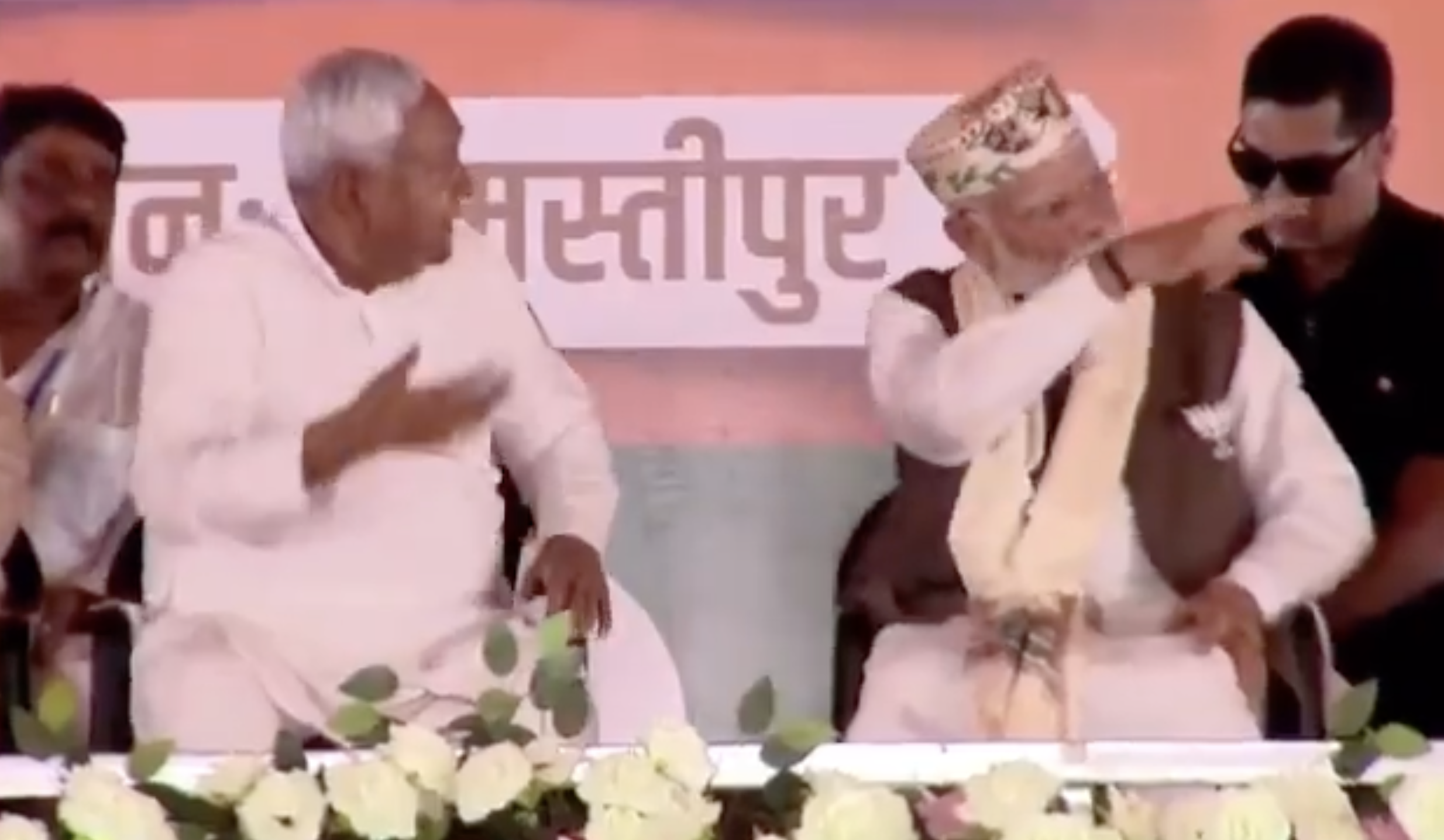 अनाउंसर की ओर नीतीश कुमार को भाषण के लिए बुलाने का इशारा करते पीएम मोदी।