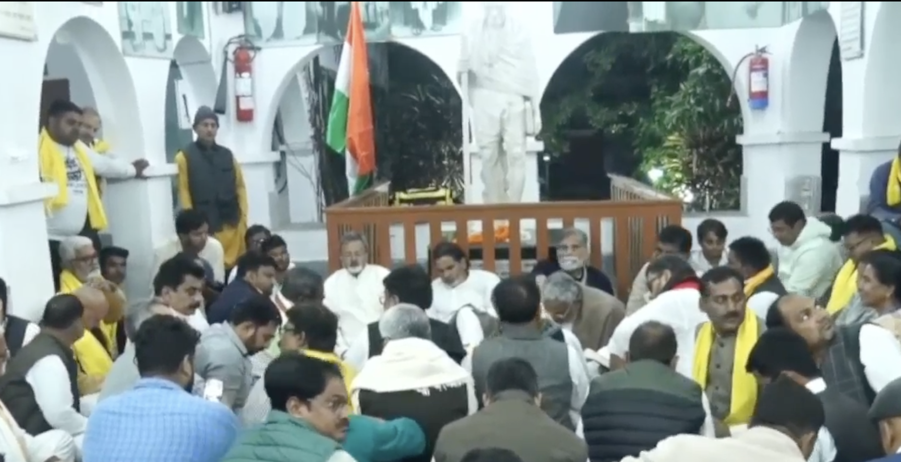 गांधी प्रतिमा के सहयोगियों संग बैठे प्रशांत किशोर।