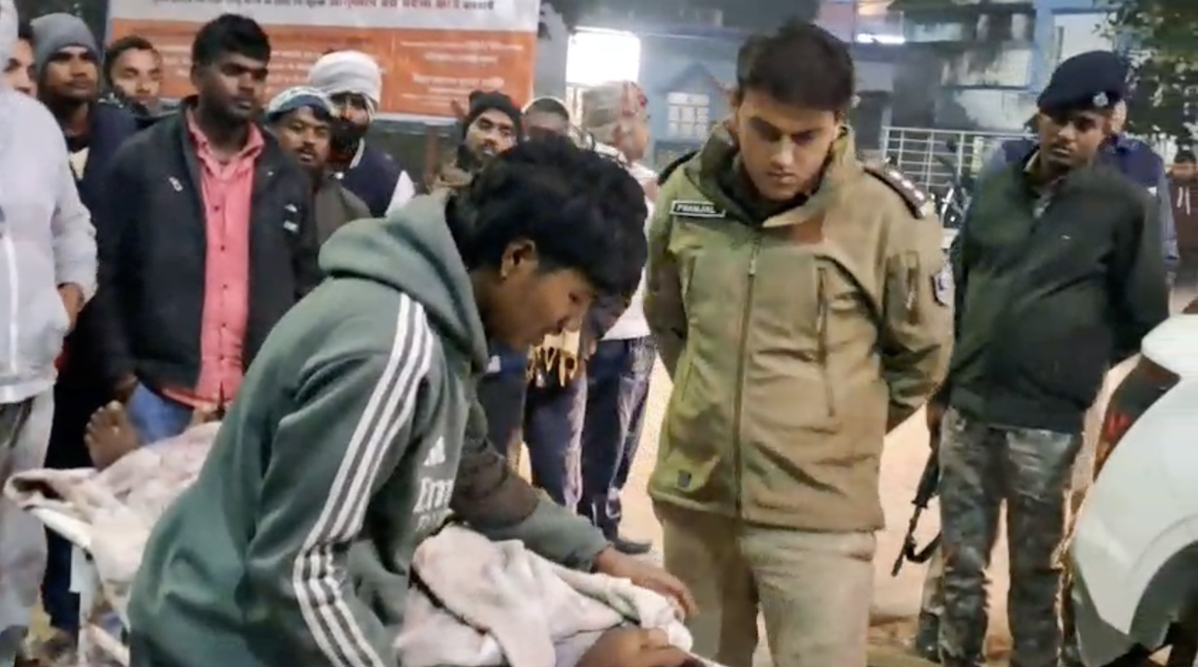 पुलिस अफसर को मृतक को लगी गोली का निशान दिखाता परिजन।