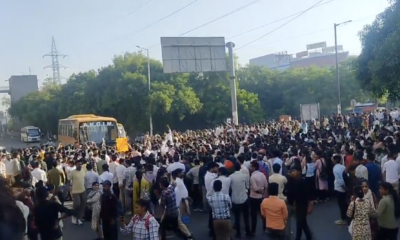 नोएडा में प्रदर्शन के दौरान एक बस को घेरते प्रदर्शनकारी।