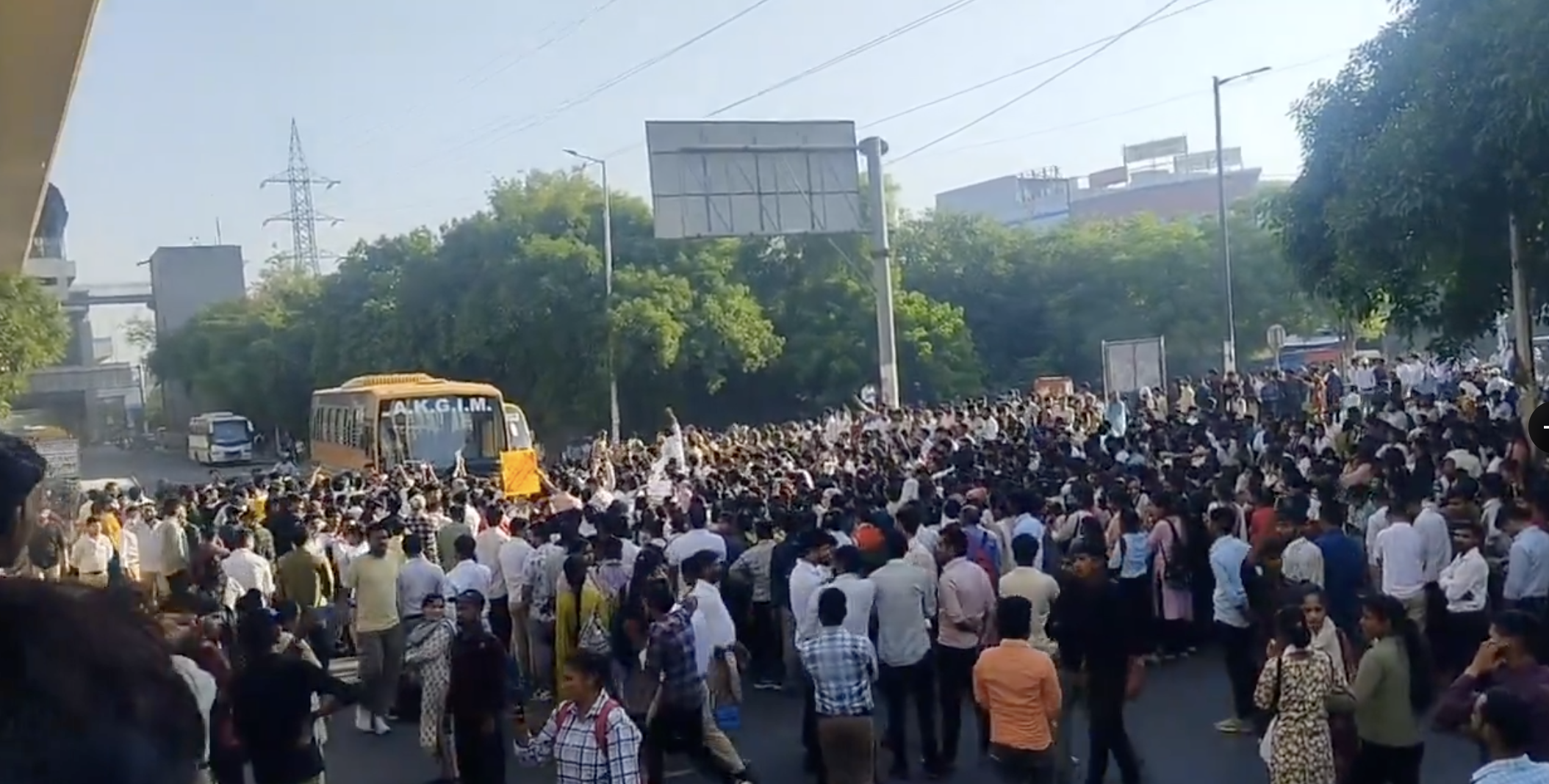 नोएडा में प्रदर्शन के दौरान एक बस को घेरते प्रदर्शनकारी।