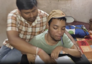 फैजान के दोनों हाथ काम नहीं करते हैं इसलिए उन्होंने मुंह के कलम पकड़कर लिखने का अभ्यास किया। (screen grab - X/@NewsArenaIndia)