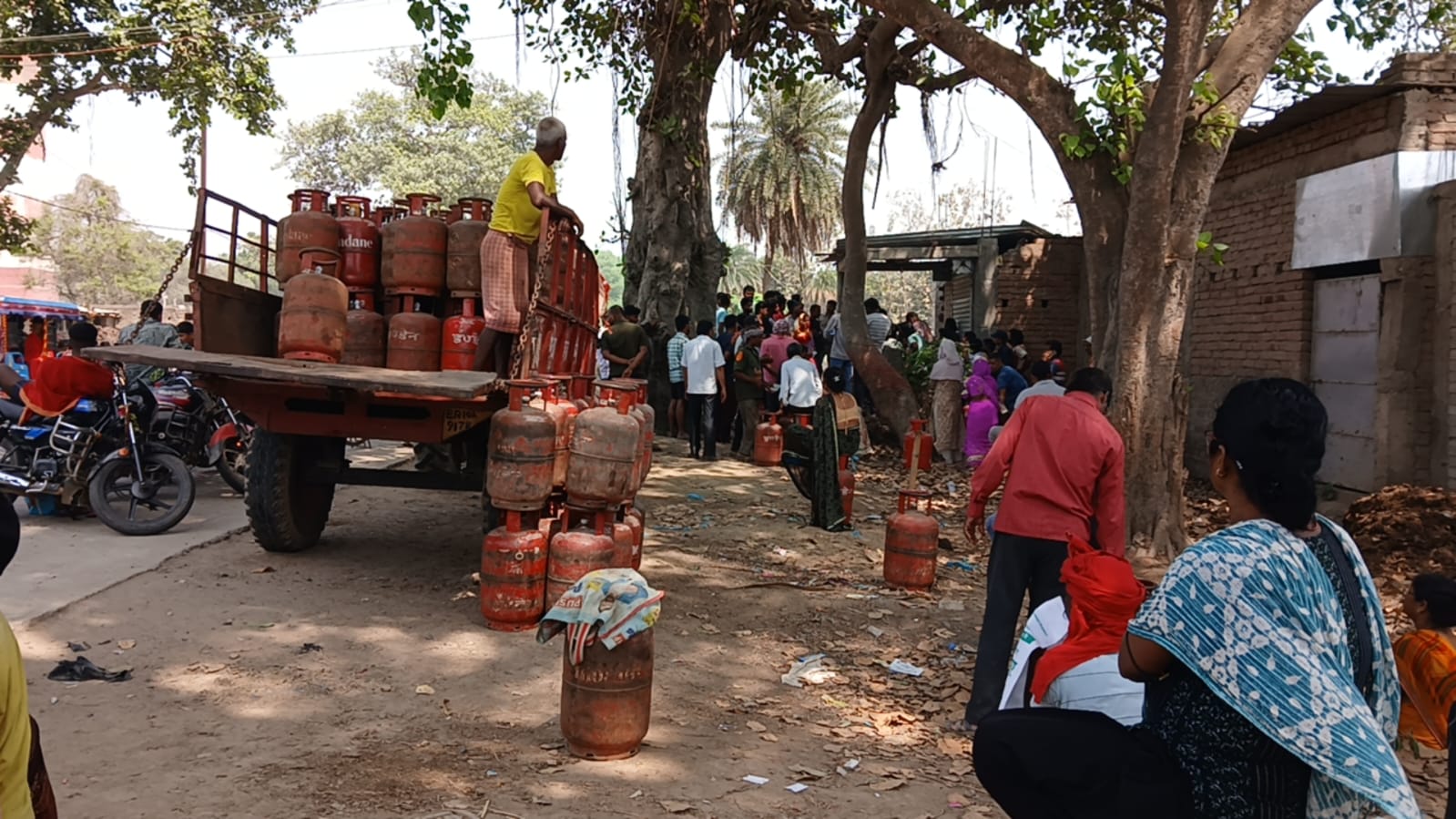 गैंस एजेंसी पर खाली सिलेंडर लिए खड़े लोग।